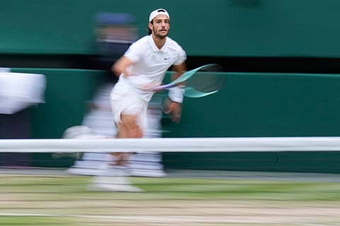 Lorenzo Musetti runs to play a return to Novak Djokovic